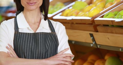 Confident store employee standing in produce aisle