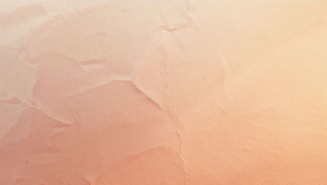 Textured plaster wall with warm peach stucco patterns