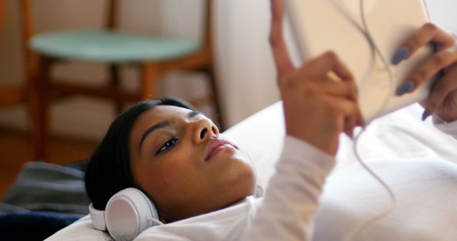 Young Woman Relaxing in Bed with Tablet and Headphones - Download Free Stock Images Pikwizard.com