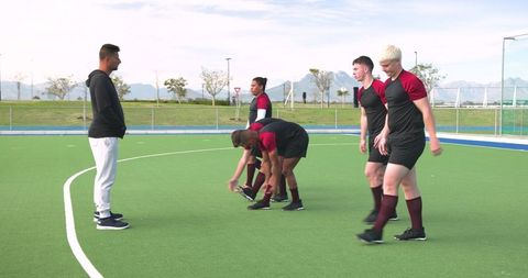 Diverse Soccer Team Preparing for Practice on Turf Field