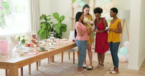 Group of Friends Celebrating with Tea and Desserts at Home