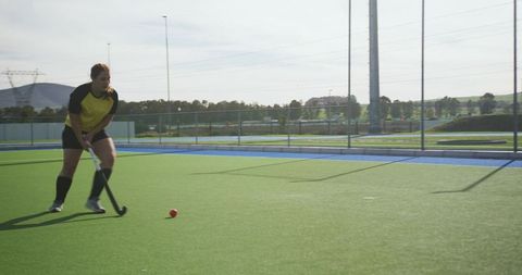 Female field hockey player practicing on turf field