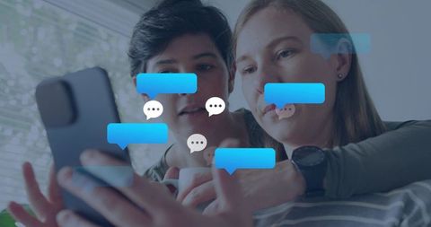 Two women leaning in checking smartphone with floating chat bubbles, casual friendship