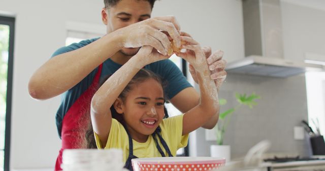 Father and daughter enjoying baking together in the kitchen, with flour on their hands and faces. Great for depicting family bonding, home activities, fun parenting, and healthy parent-child relationships.