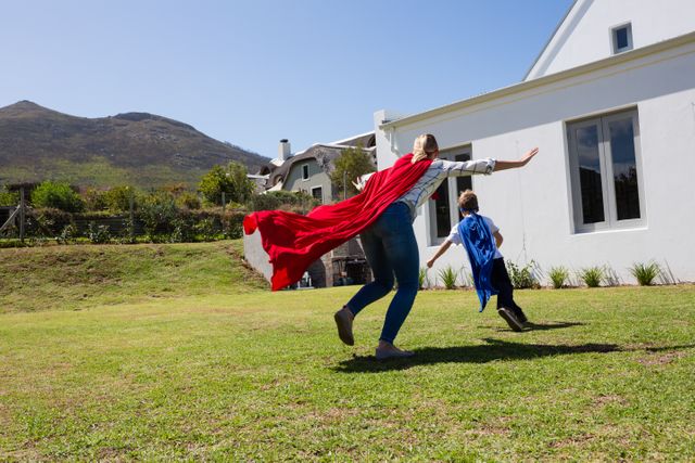 Mother and son in superhero costume playing in the backyard on a sunny day