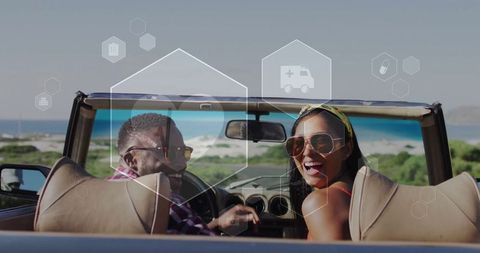 Joyful multicultural couple driving convertible along scenic coastal highway