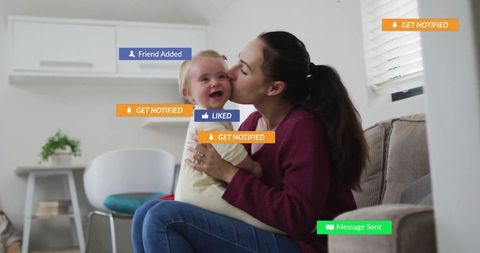 Mother kissing baby at home with social media interaction signs