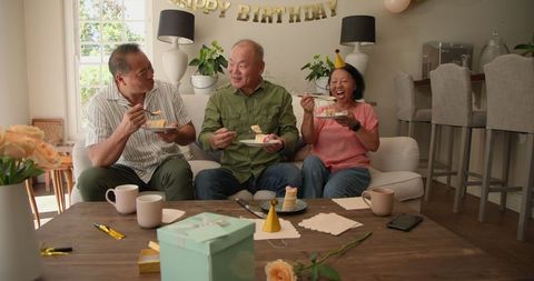 Seniors Celebrating Birthday at Home Enjoying Cake Together