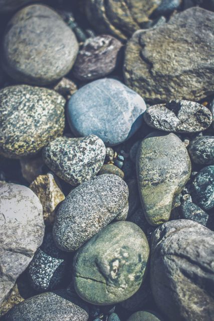 Detail of various colorful pebbles and rocks showing textures. Ideal for use in nature-themed projects, backgrounds, presentations, and educational materials on geology.