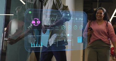 Office coworkers walking through glass door while viewing holographic business dashboard