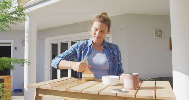 Woman Varnishing Wooden Table Outside Her Home on a Sunny Day - Download Free Stock Images Pikwizard.com