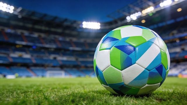 Close-up soccer ball resting on grass pitch under stadium floodlights, night sports background