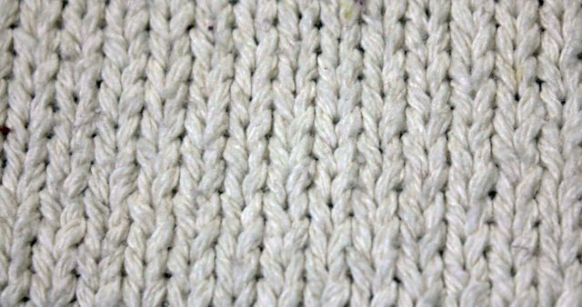 Close-up of detailed knitted wool texture showcasing intricate stitching. Ideal for craft blogs, knitting tutorials, textile design inspiration, or showcasing the intricacies of handmade fabric products.