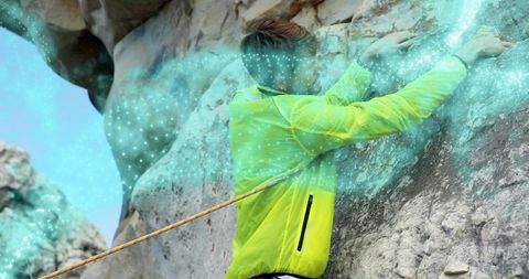 Solo climber scaling steep limestone cliff wearing neon jacket with glowing turquoise trail
