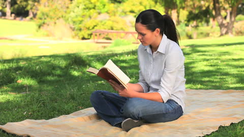 Woman Enjoying Relaxing Day Reading in a Park