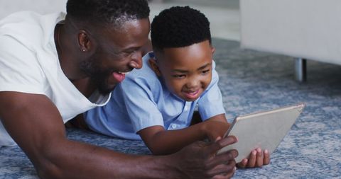Happy African American Father and Son Bonding Over Tablet