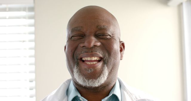 Smiling African American doctor in white coat with bright background - Download Free Stock Images Pikwizard.com