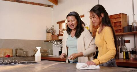 Mother and Daughter Cleaning Kitchen Together, Embracing Teamwork