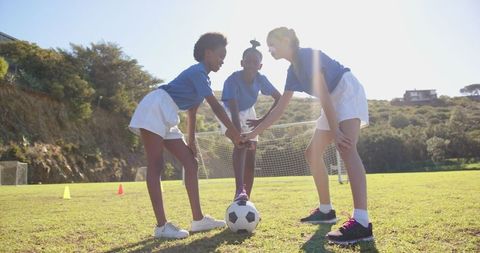 Diverse Young Female Soccer Players Engaging in Team Spirit Ritual
