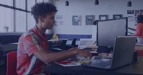 Creative professional sorting papers in modern workspace