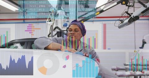 Female technician wiping car with digital diagnostics overlay in robotic garage workshop