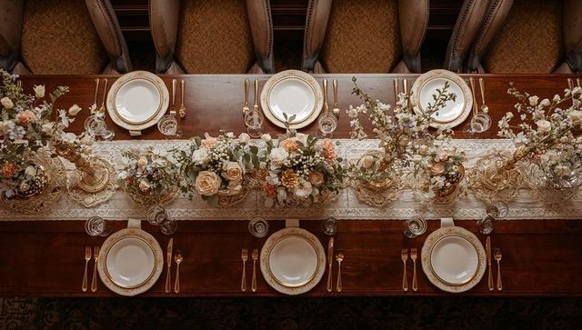Elegant vintage banquet table with lace runner, rose and eucalyptus centerpieces