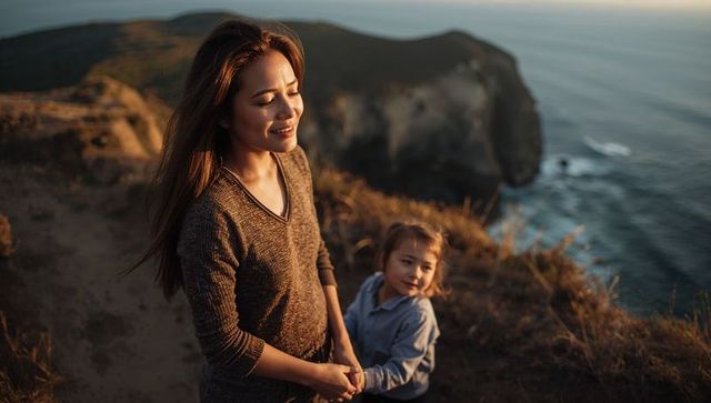 Mother and child holding hands on coastal cliff at golden hour sunset tender moment