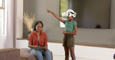 African American Mother and Daughter Exploring VR at Home with Tablet and Headset