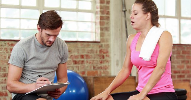 Personal Trainer Taking Notes While Client Catches Breath After Workout - Download Free Stock Images Pikwizard.com