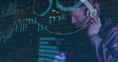 Young man listening with headphones while analyzing stock charts on smartphone