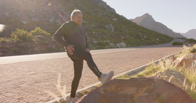 Senior Man Stretching on Mountain Road During Morning Exercise - Download Free Stock Images Pikwizard.com