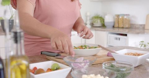 Woman Cooking Healthy Meal with Fresh Vegetables in Modern Kitchen