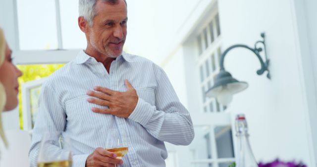 Mature Man Toasting with Wine at Casual Indoor Gathering - Download Free Stock Images Pikwizard.com