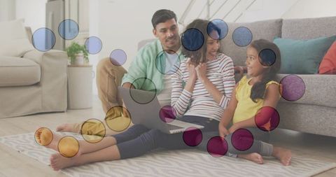 Family sharing laptop on living room floor laughing together on patterned rug
