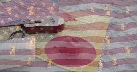 Resting red straw sun hat and ukulele on yellow-striped beach towel with flag overlay