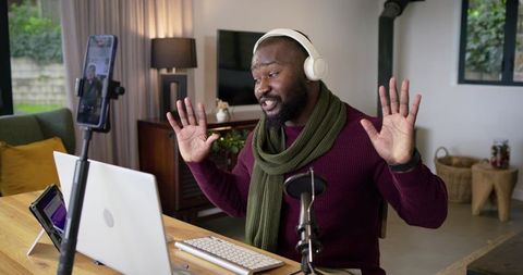 African American man presenting live from home studio streaming podcasting with headphones