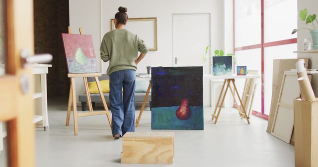 Image of back view of biracial female artist painting in studio - Download Free Stock Photos Pikwizard.com