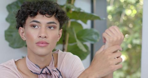 Fashionable young man with curly hair in artistic studio setting