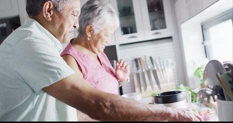 Senior Couple Preparing Healthy Drink Together in Kitchen