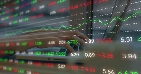 Hands typing on laptop with financial data displayed