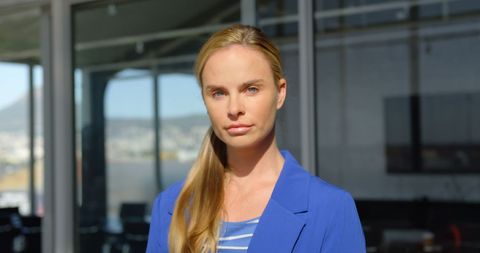 Serious Businesswoman Standing in Sunlit Office