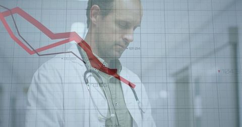 Doctor analyzing declining chart in hospital corridor