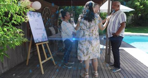 Backyard 60th Birthday Party Adults Laughing and Chatting on Poolside Wooden Deck