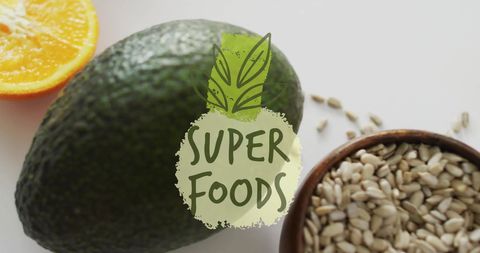 Healthy superfoods including avocado, orange slice, and seeds