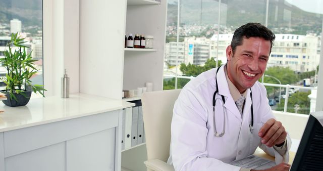 Doctor in Office Smiling While Using Laptop - Download Free Stock Images Pikwizard.com