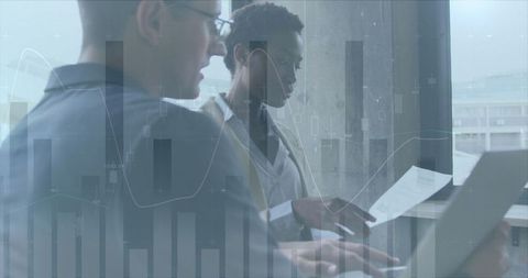 Business Colleagues Analyzing Data Graphics in Office Setting