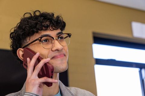 Young professional talking on smartphone while smiling in modern office