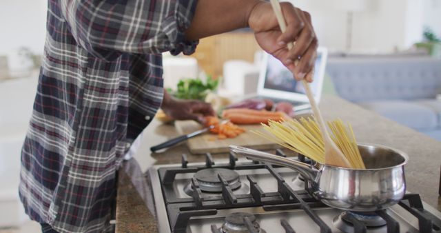 Senior Man Cooking at Home, Adding Spaghetti to Pot - Download Free Stock Images Pikwizard.com