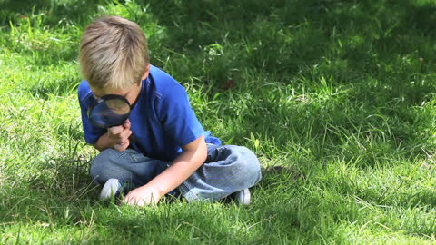 Curious Boy Exploring Nature with Magnifying Glass