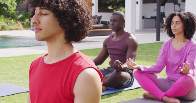 Three individuals from different backgrounds engage in meditation outdoors on a sunny day. This tranquil scene can be used in wellness, health, and relaxation campaigns, promoting mindfulness and mental peace. Ideal for blogs, websites, and social media posts related to self-care, yoga retreats, and mental health awareness.